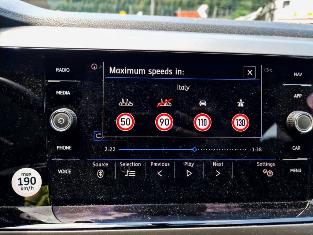 Italian Toll Roads: Ultimate Guide To The Italian Autostrada 7 A car's infotainment screen displays maximum speed limits for Italy: 50 km/h in urban areas, 90 km/h on secondary roads, 110 km/h on main roads, and 130 km/h on motorways. A speedometer sticker shows a max speed of 190 km/h.