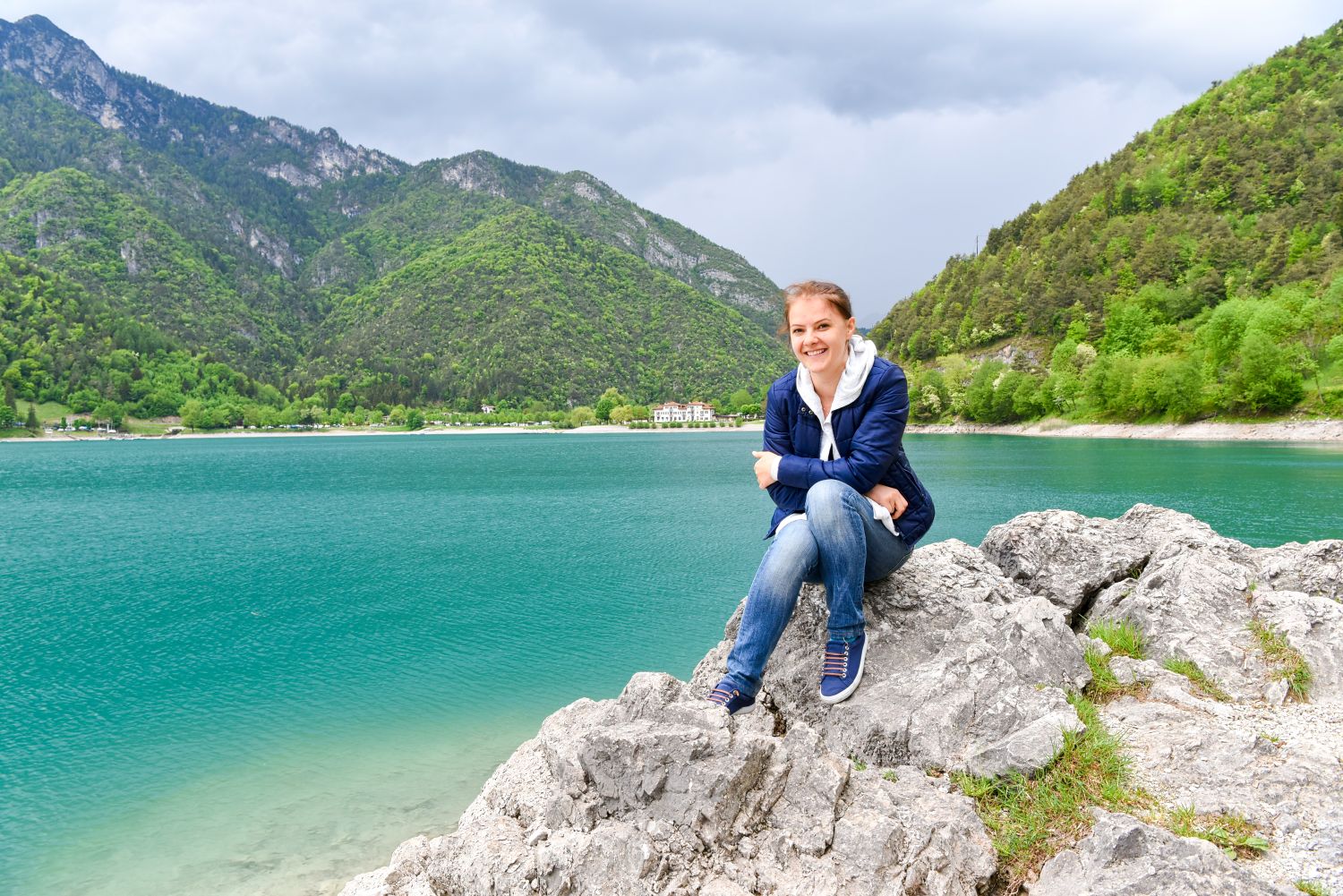 11 beautiful lakes in Northern Italy 11 A woman sitting on a rock by a body of water.